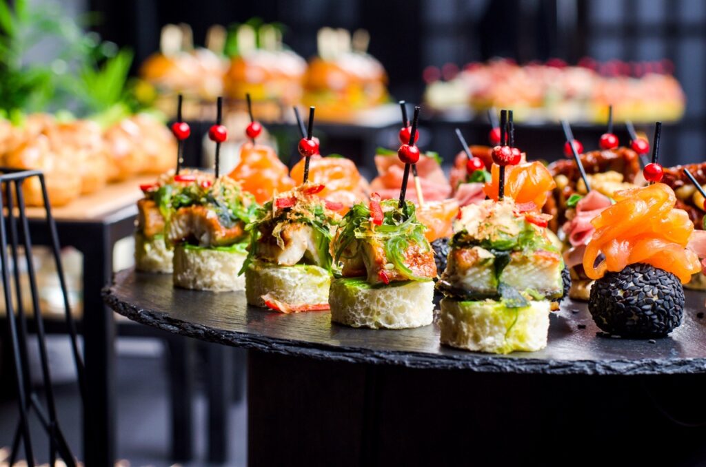 Set of beautiful canapes on black stone plates. Buffet table. Catering.