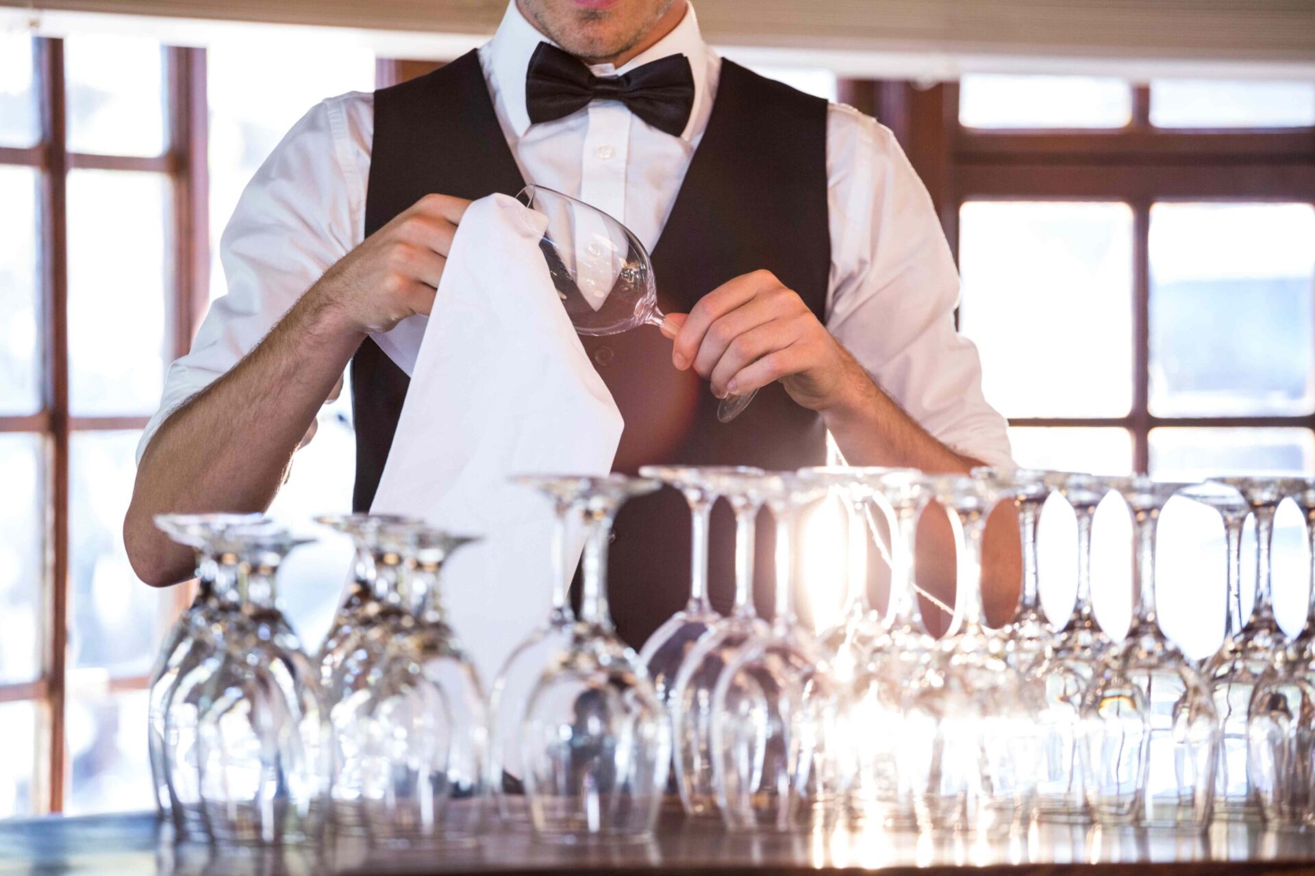 Servicekraft bereitet Gläser vor einer Veranstaltung vor – Eventpersonal in Berlin-Mitte